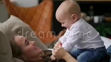 生命中最美好的时刻，一位充满爱心的年轻母亲在雪白的毯子上，在洁白的毯子上拥抱一个哺育的儿子